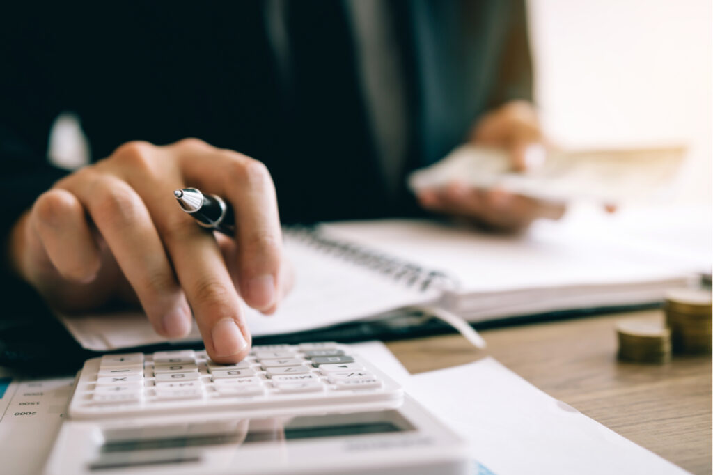Man using a calculator while doing the match for his retirement savings.