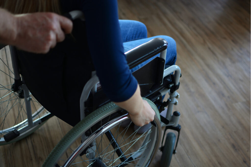 Young woman sitting in a wheelchair getting ready for multiple sclerosis physical exercise.