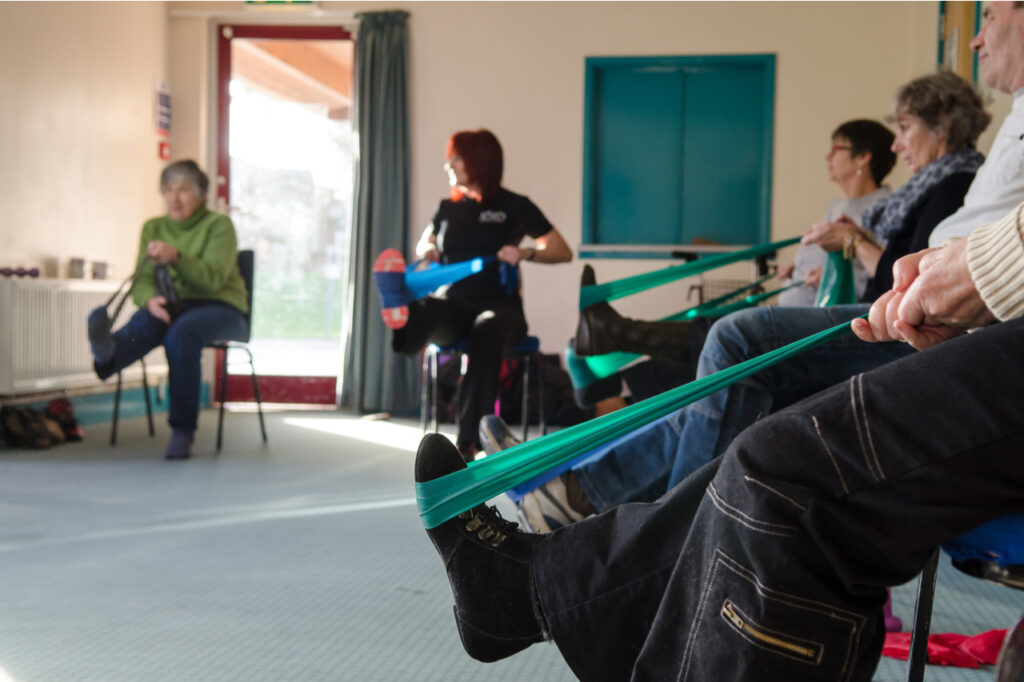 Occupational therapy instructor provides training exercises for multiple sclerosis patients at health center.