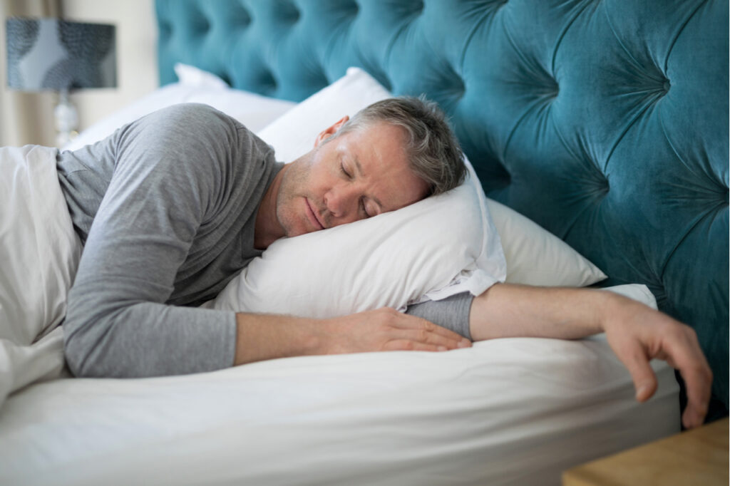 Man sleeping on bed in bedroom at home from lack of sleep.
