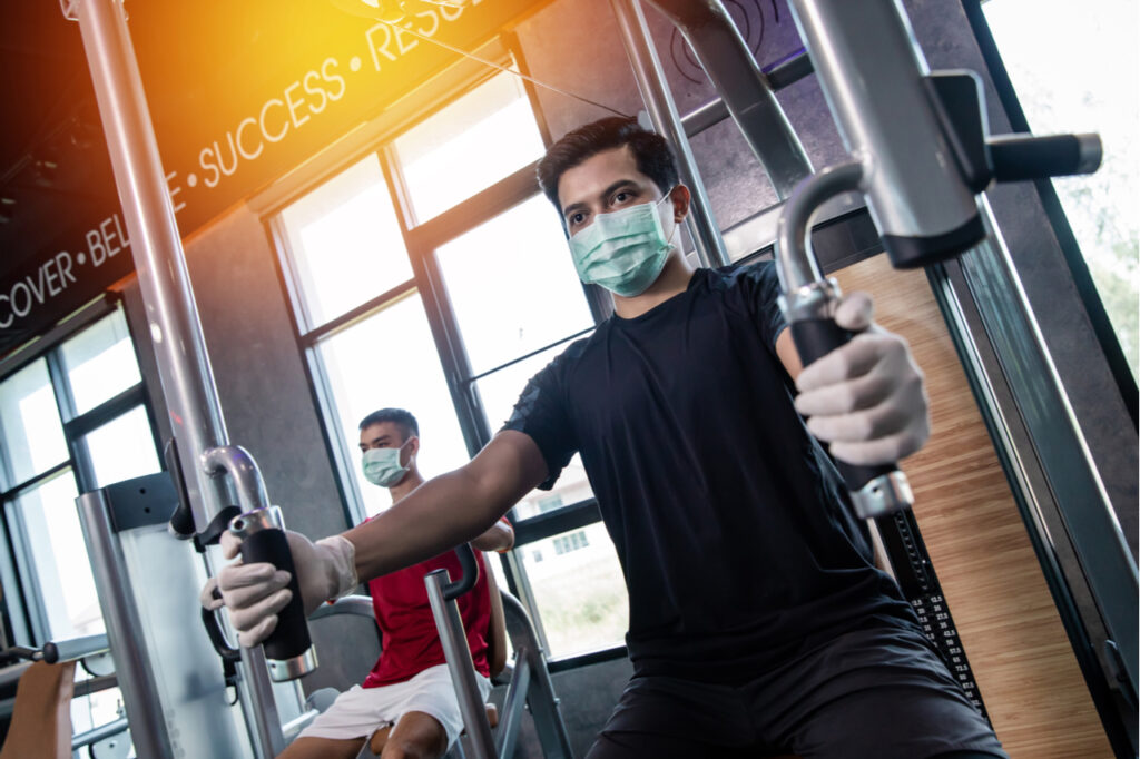 Asia men working out wearing surgical mask & latex rubber gloves.
