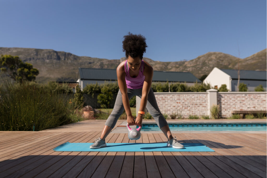 Woman exercising with kettlebell and should try using the kettle gryp kettlebell adjustable portable weight grip.