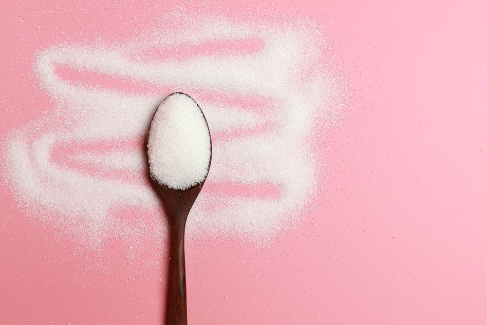 White sugar on a pink background