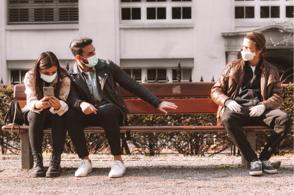 corona covid-19 social distancing concept picture with three people wearing face masks - stay away