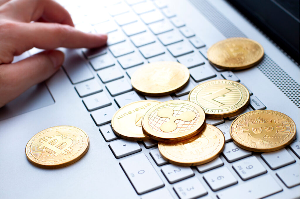 Different types of crypto coins on the computer keyboard close up