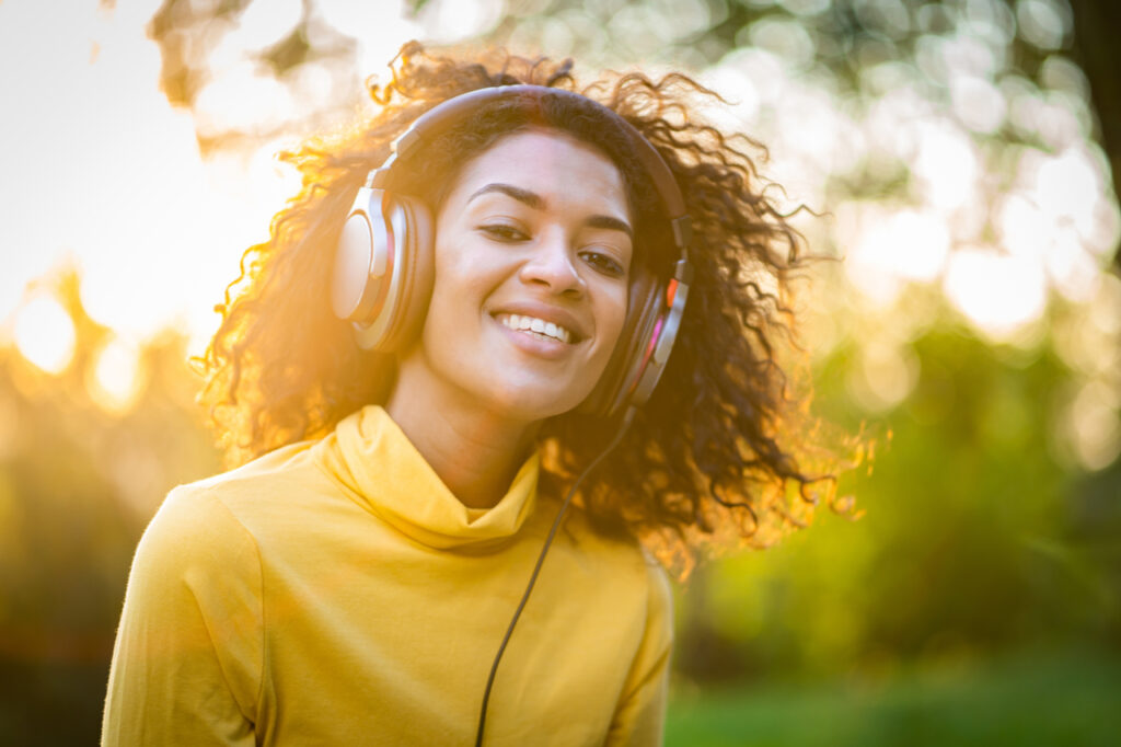 African american woman listing to music showing good emotional health.
