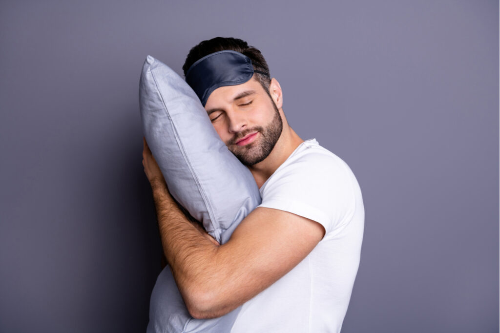 Close-up portrait of his he nice attractive bearded guy holding cbd pillow.