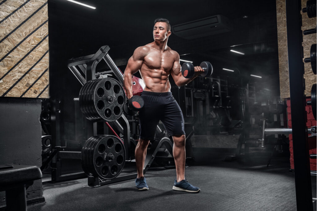 Man with big muscles trains in the gym caused by trx training.