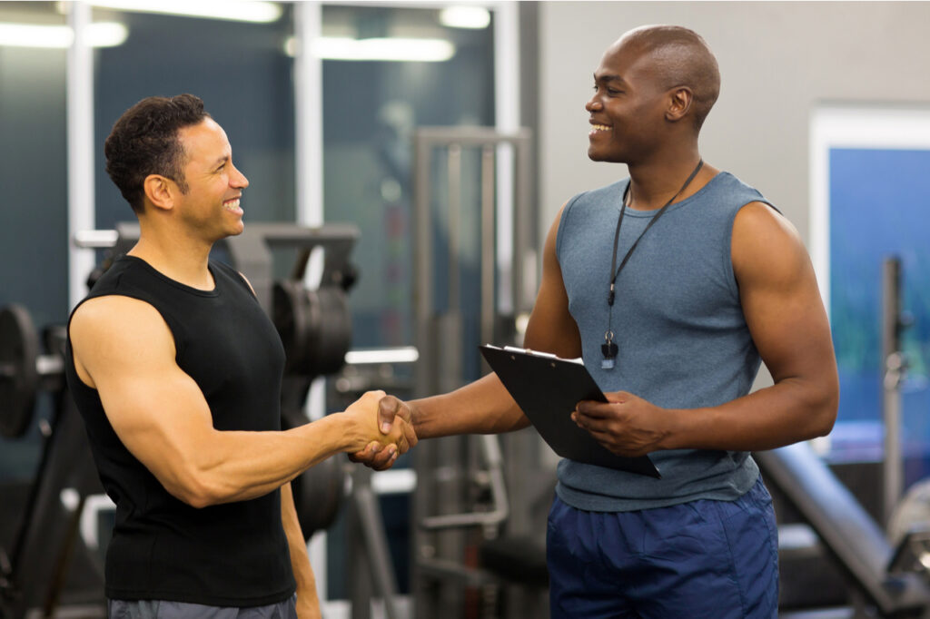 Friendly personal trainer shaking hands with a client.