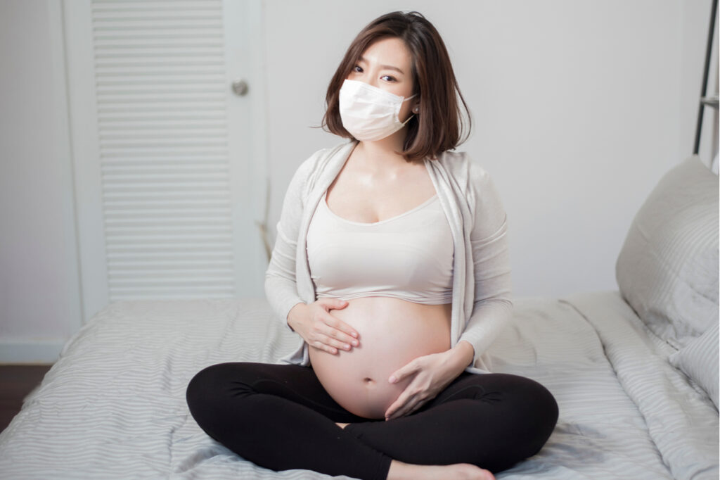 COVID-19 and pregnancy makes a pregnant woman wear protective mask in her home.
