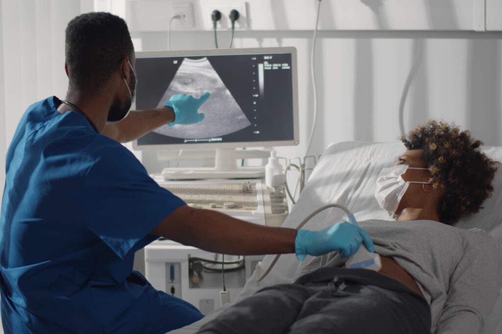 Pregnant woman in safety at ultrasound office in modern clinic.
