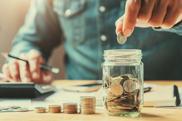 Man saving up change in a jar.