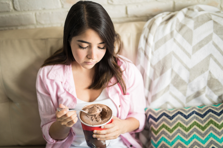 Woman depressed eating chocolate ice cream.