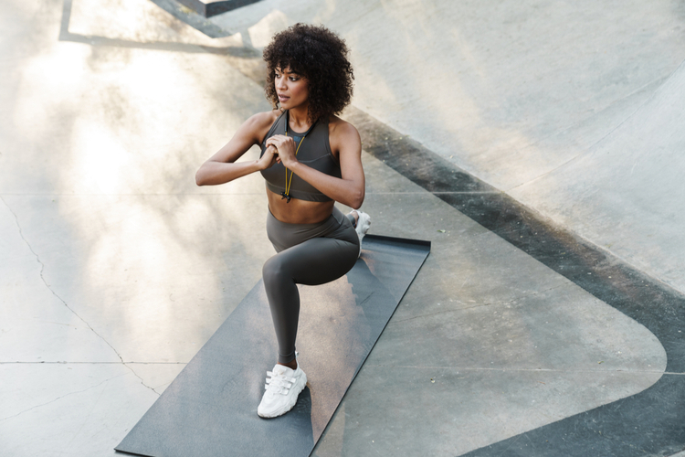 Sportswoman doing exercise while working out on sports ground as part of how to be healthy.