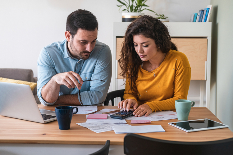 Young couple calculating their domestic bills at home.