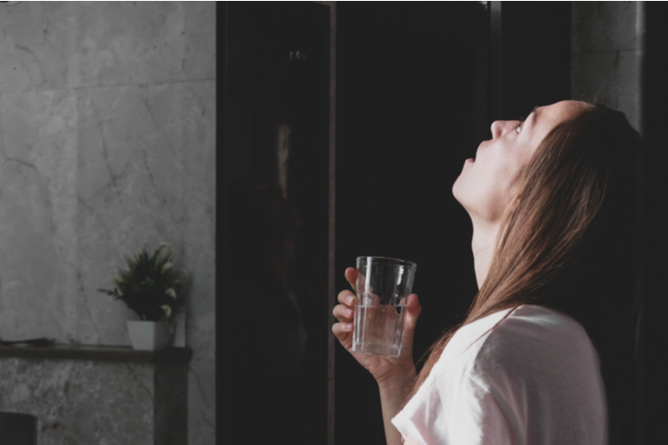 Woman gargling salt water.