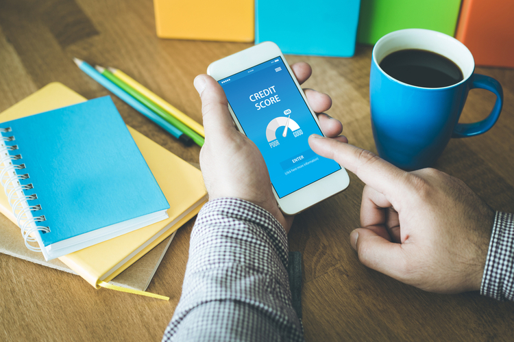 Man checking his credit score online using a mobile phone planning on how to build your credit.