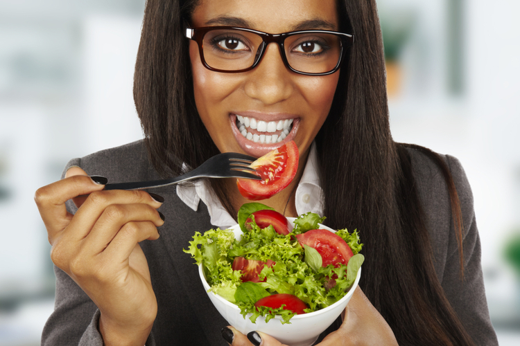 Businesswoman eating fresh tomatoes.