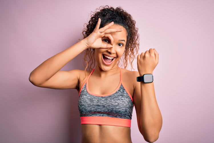 Woman showing off her Garmin Venu smartwatch and doing ok sign.
