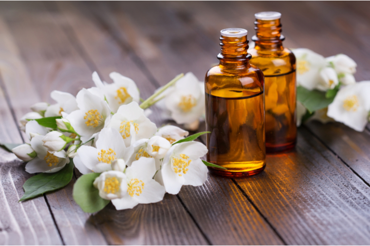 Essential aroma oil with jasmine on wooden background.