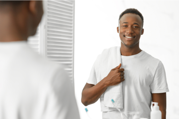 Young man holding a towel going to the shower.