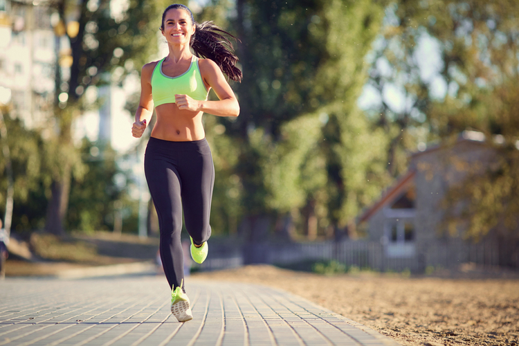A brunette runner woman runs in the park jogging.