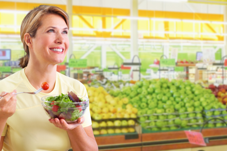 Elderly woman eating salad.