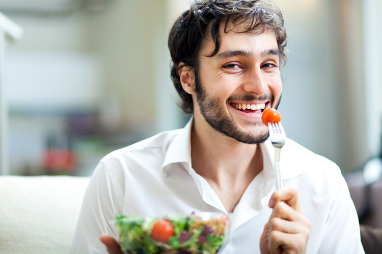 Young man eating a healthy salad.