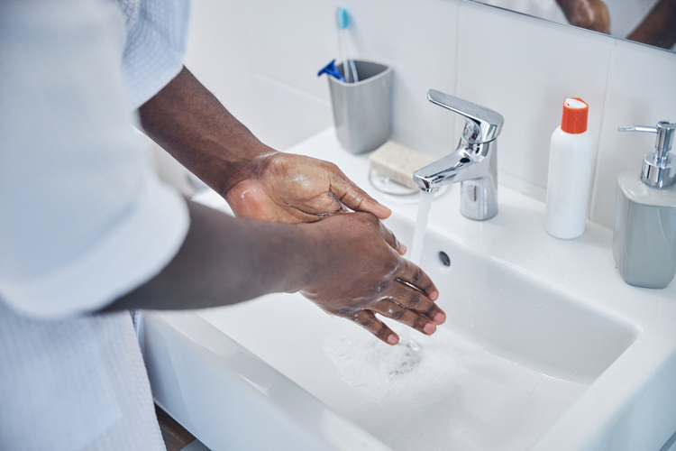Conscious young man using soap for washing his hands after taking thorne zinc picolinate.