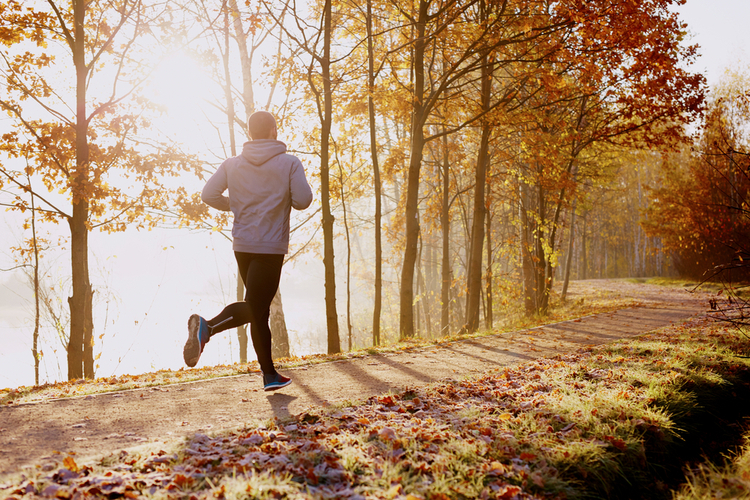 Man running in park at autumn morning.