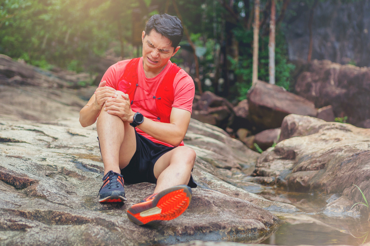 A runner having knee pain while having a run.