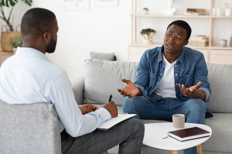 Stressed man explaining his problems to psychologist at individual therapy session.