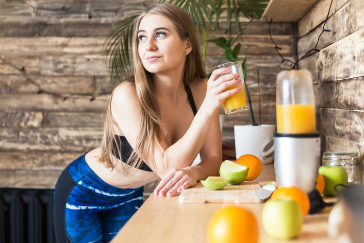 Attractive girl in sportswear prepares a healthy breakfast before the running.