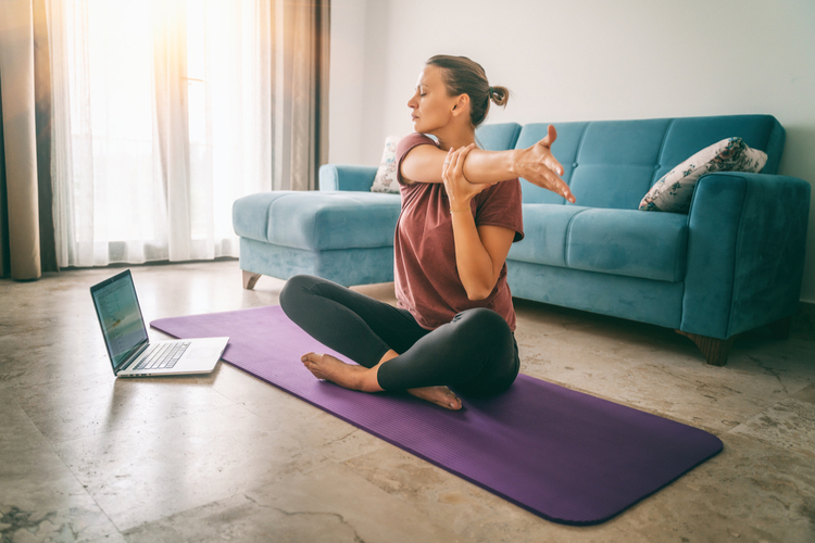 young woman doing yoga stretching yoga online at home.