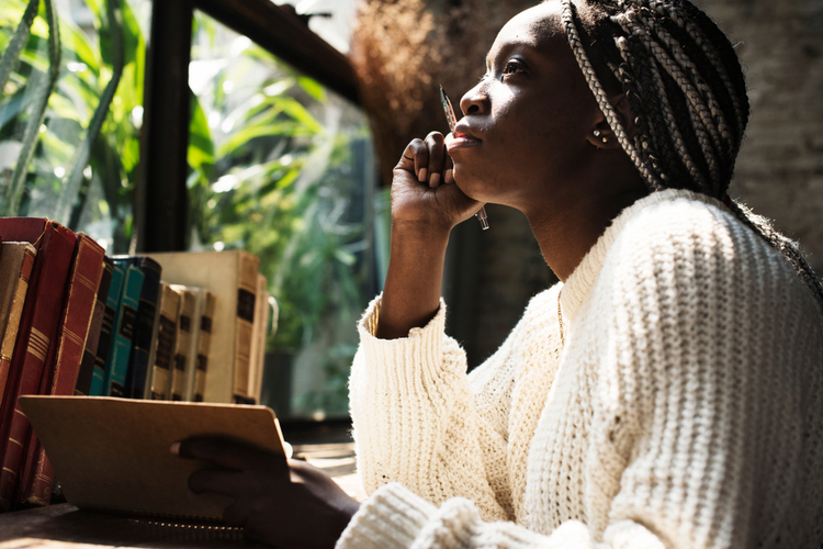 Portrait of black woman with journaling. 