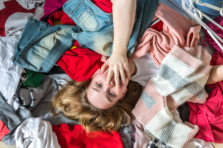 Fast fashion, the girl puts things in order in the closet in need of a sustainable shopping.