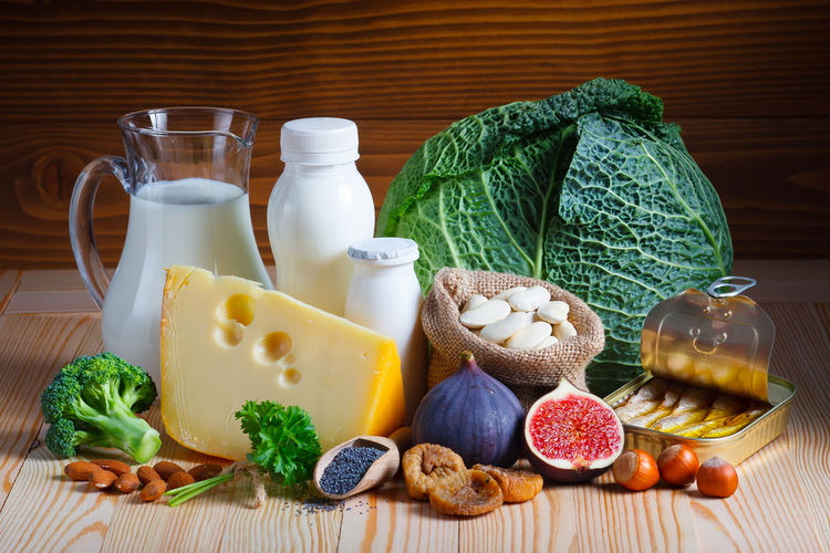 An assortment of calcium-rich foods on a wooden surface.