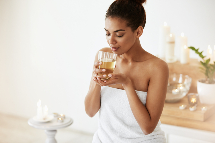 Attractive girl drinking garden of life green tea extract after taking a bath.