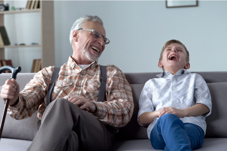 Grandparent and boy laughing genuinely while talking about their family history.