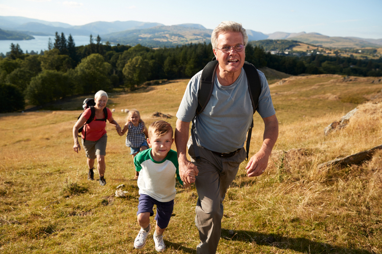 Grandparents and children climbing a hill together.