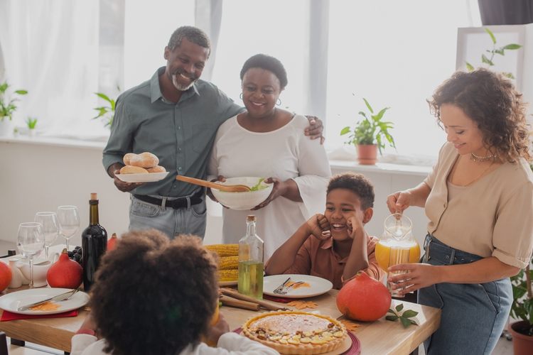 Grandparents holding food near family celebrating Grandparents Day.