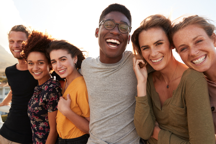 Portrait of smiling young friends walking outdoors.