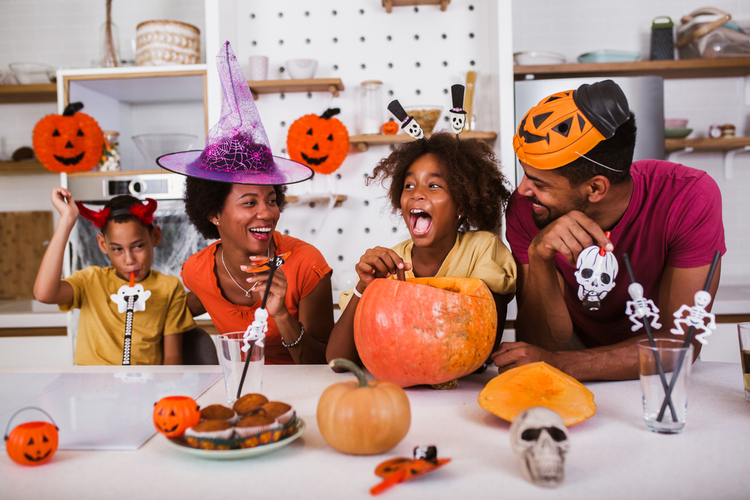 Happy family mother father and children prepare for Halloween.