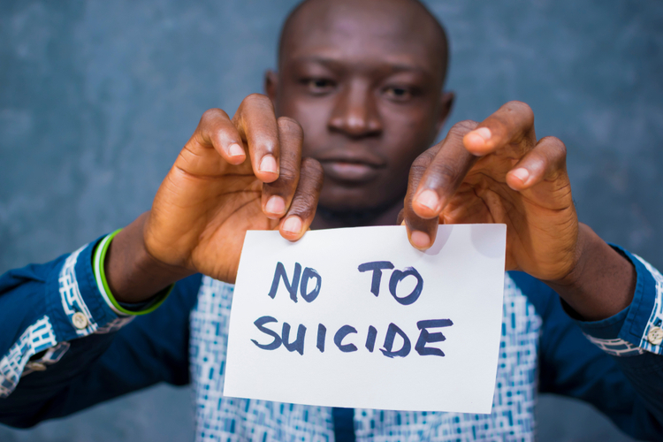 young man holding a placard of NO to SUICIDE