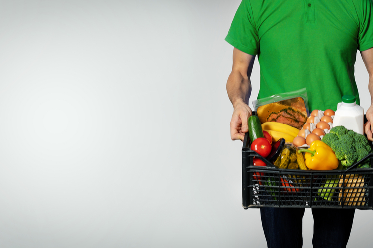 imperfect foods review of a man with a grocery box on gray background