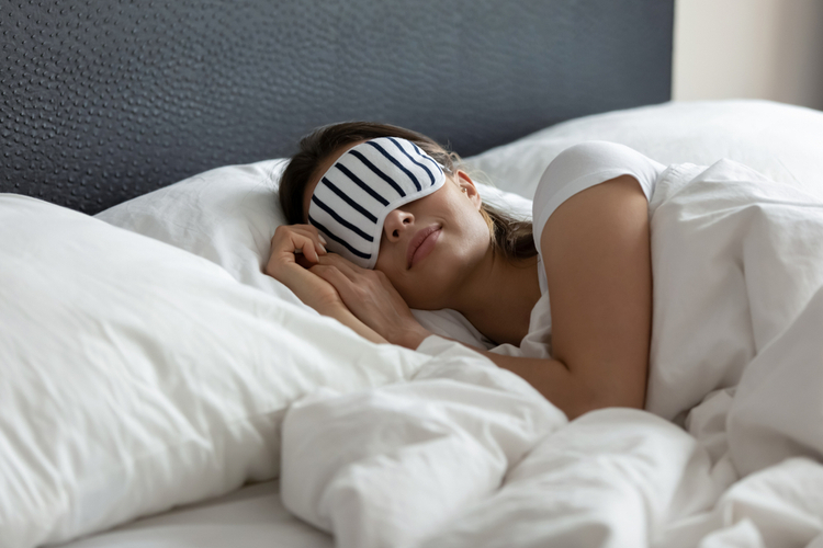 Comfy sleeping mask helping young woman tourist traveler enjoy good healthy night sleep