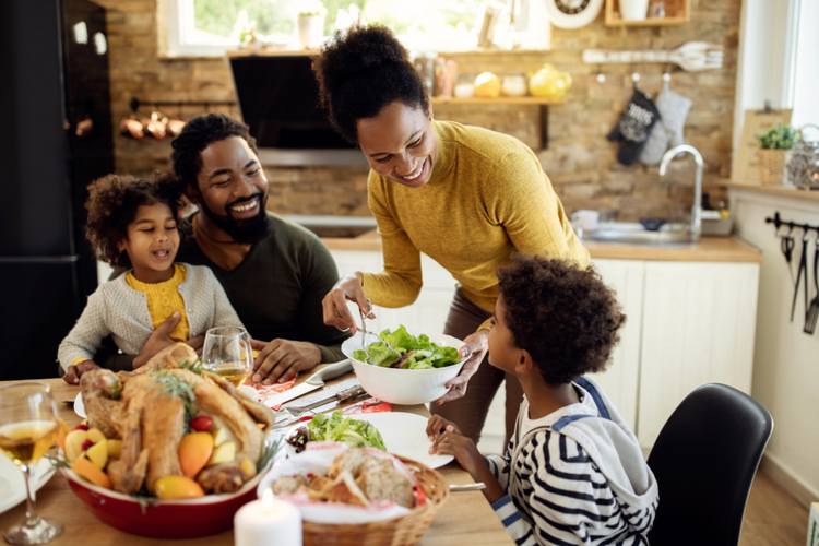 Happy African American Woman Having Thanksgiving Lunch with her Family.