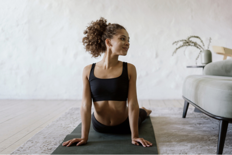 Happy and healthy afro american sporty and fit woman training for upper body workout at home on yoga mat.