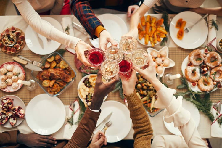Top View Background of People Raising Glasses Over Festive Dinner Table While Celebrating Christmas with Friends And Family