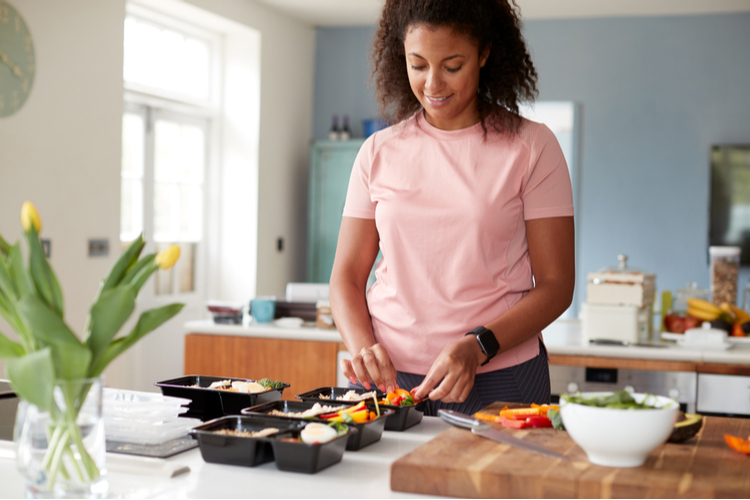Woman preparing portion controlled meal at home kitchen.